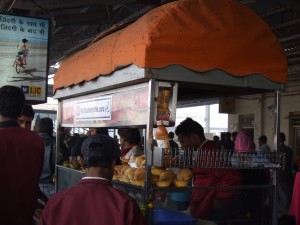 Snack stand in the Agra train station.  Observe the orange cover.